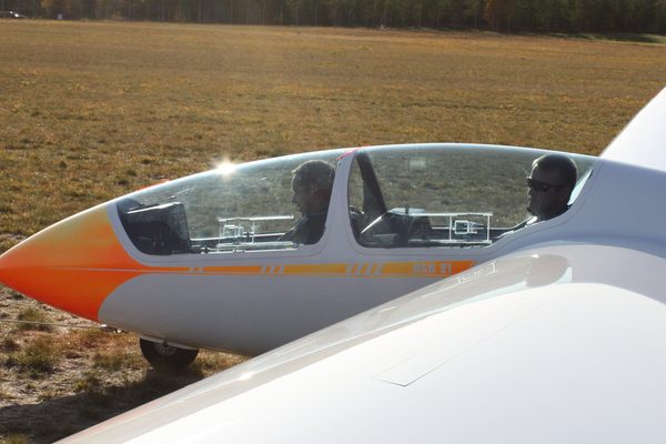 A two-seat glider on the field in low autumn sun, ready for the next launch.